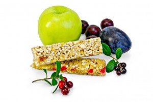 Granola bar, green apple, plum, cherry, branches with leaves and berries lingonberries isolated on white background